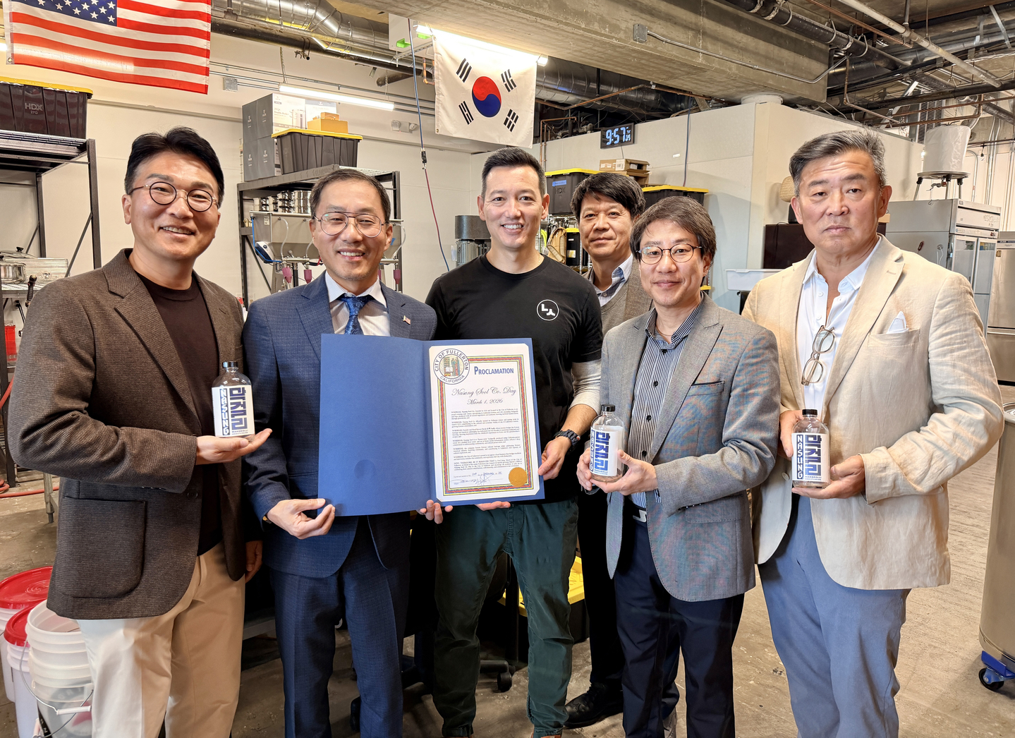 ‘나성 술’을 방문한 프레드 정(왼쪽 두 번째부터 차례로) 풀러턴 시장이 데이비드 포크 대표에게 나성 술의 날 선포문을 전달하고 있다. [풀러턴 시장실 제공]