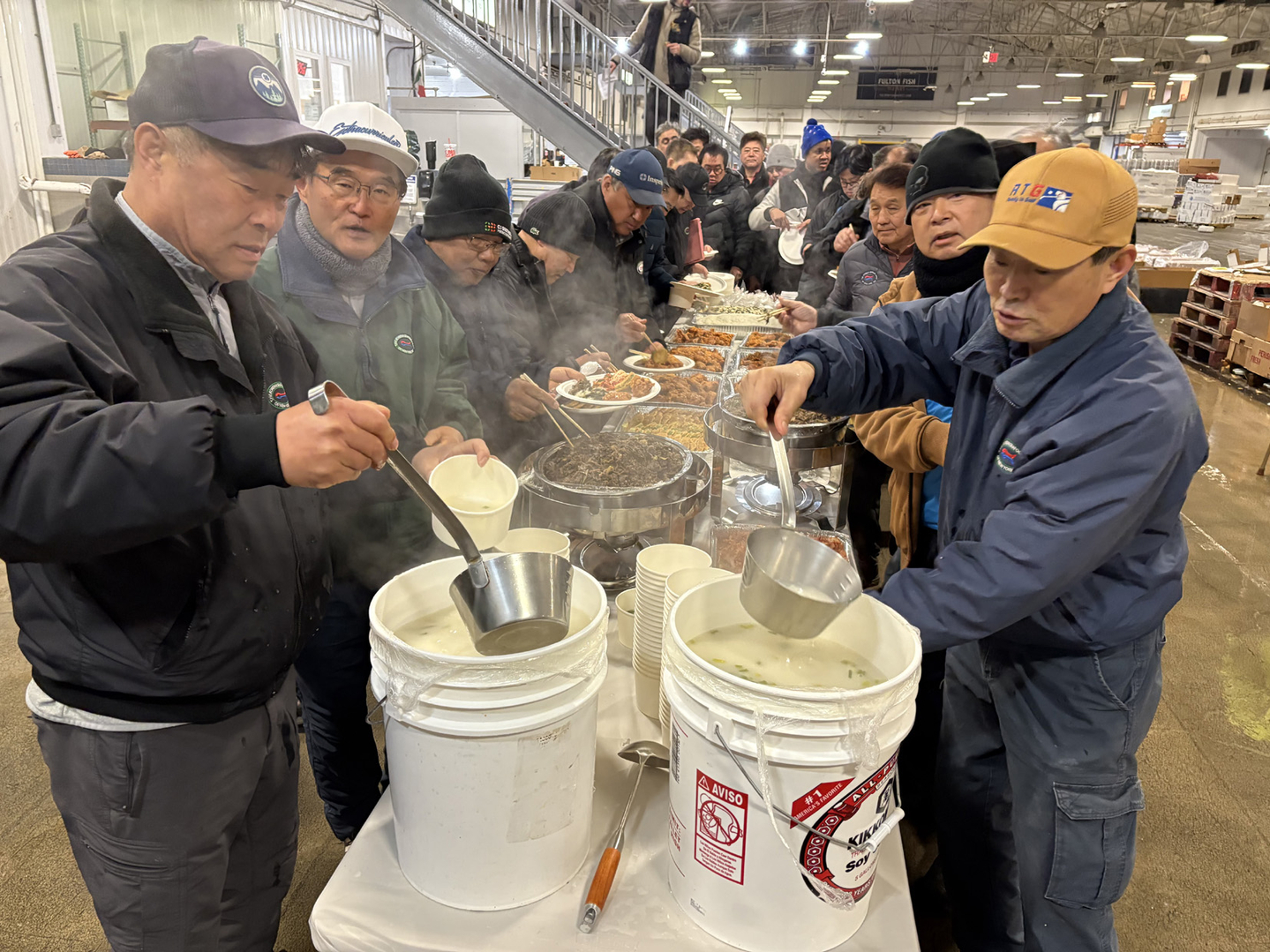 뉴욕한인수산인협회는 19일 뉴욕시 브롱스 풀턴 피시마켓에서 회원과 도매상인 등 300여 명이 떡국과 불고기, 전 등 음식을 함께 나누는 떡국잔치를 열고, 서로의 수고를 격려하고 새해 건강과 사업번창을 기원했다. [뉴욕한인수산인협회] 