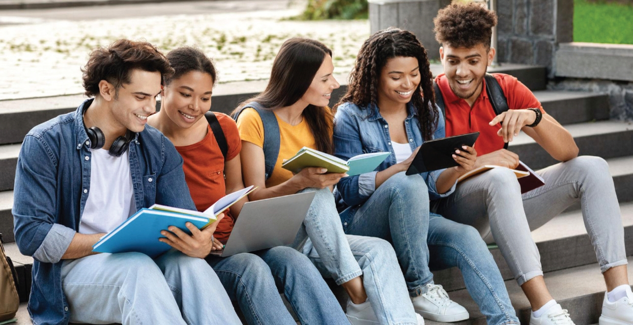 캠퍼스 계단에 나란히 앉은 학생들이 책과 태블릿을 보며 함께 공부하고 있다. [로이터]