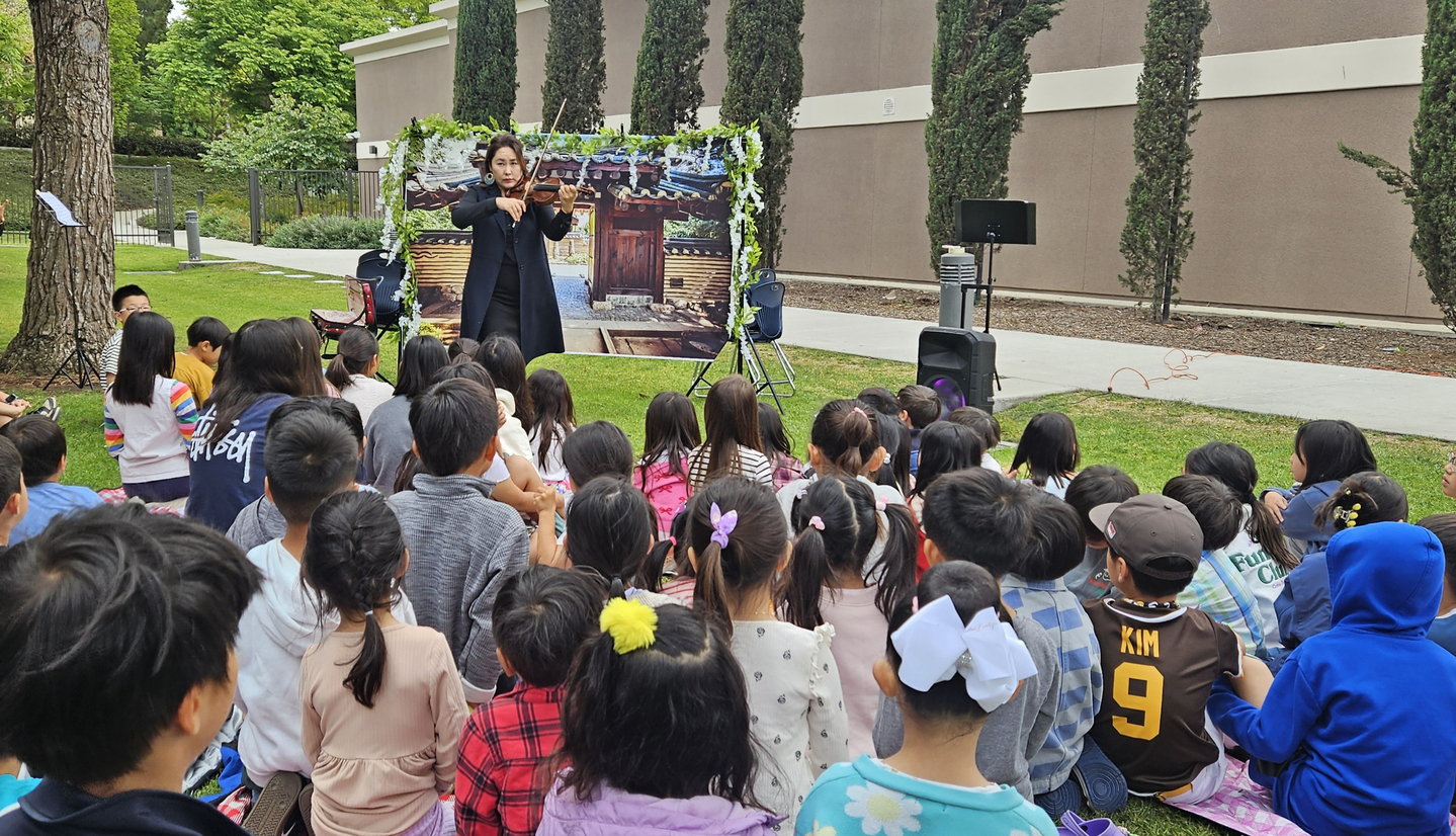 남가주 한국학원 어바인 한국학교(교장 장영임)는 지난달 25일 미니 음악회를 가졌다. 이날 음악회에서 학생들이 이태이(4학년), 이태우(3학년) 학생의 학부모 도진미씨의 바이얼린 연주를 듣고 있다. [어바인 한국학교 제공]