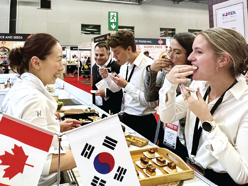 2026 몬트리올 국제식품박람회 한국관에서 진행된 시식 행사에서 관람객들이 K푸드를 맛보고 있다. [사진 한국농수산식품유통공사]