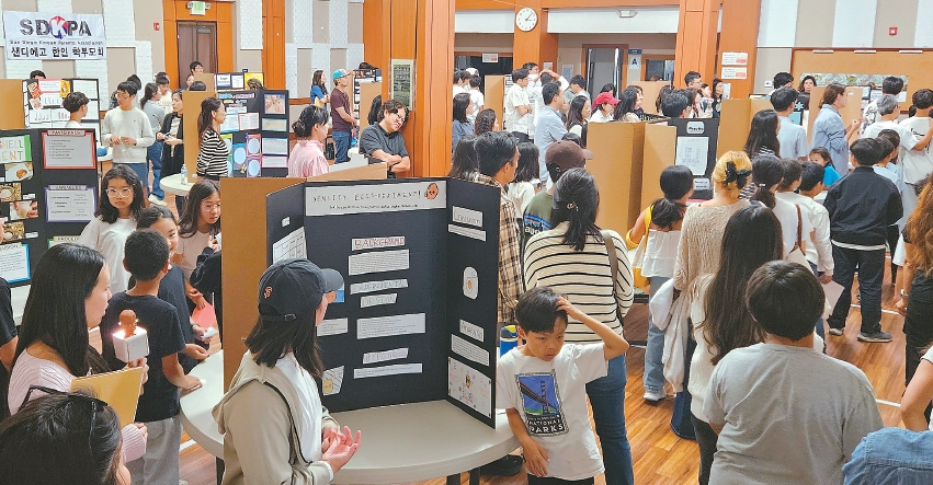 제 4회 '사이언스 페어'가 예담교회에서 열렸다. 친교실에 마련된 각 팀의 연구결과가 실린 보드 판을 많은 참석자들이 관람하고 있다.