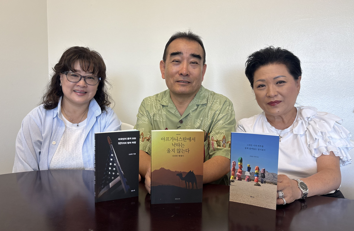 신상만(가운데) 작가가 한국디카시인협회 OC지부 김향미(왼쪽) 부회장, 박하영 사무총장과 함께 3권의 책을 보여주고 있다.